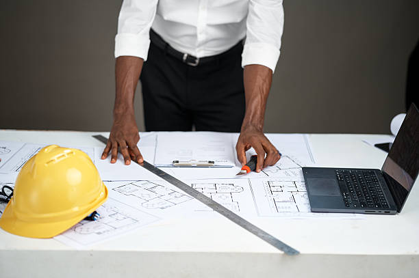 istock Young African man working on architectural plans at desk 2252115633