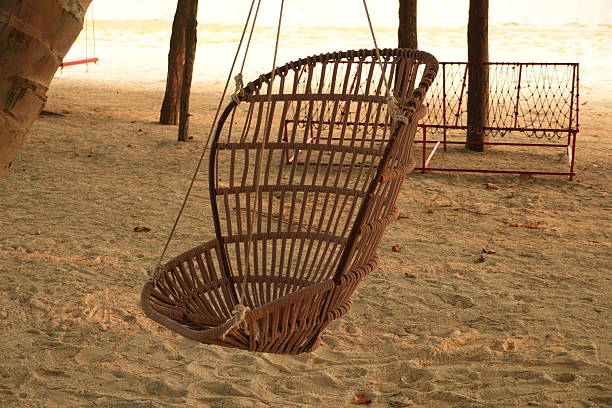 Cozy wicker swing on serene beach at sunset, perfect for relaxation and tranquility
