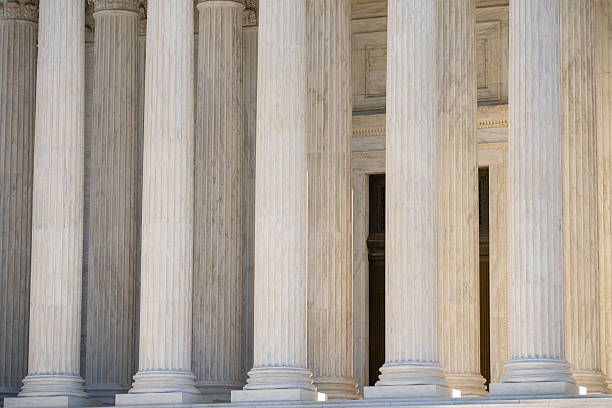 istock Classical architecture defining monumental columns. Historic government architecture with marble pillars. White stone columns shaping civic architecture. Court house exterior with classical design. 2252128656