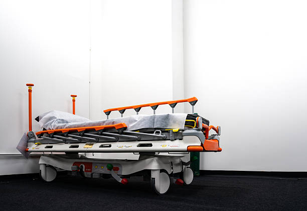 Male and female nurses pushing patient lying on stretcher in hospital.