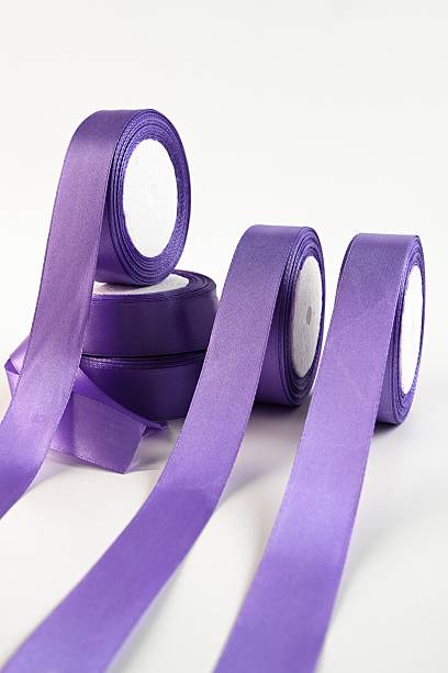 istock Violet satin ribbons in rich purple tones displayed in rolls on a light background. Smooth decorative material used for floral design craft and elegant gift wrapping. 2252132857