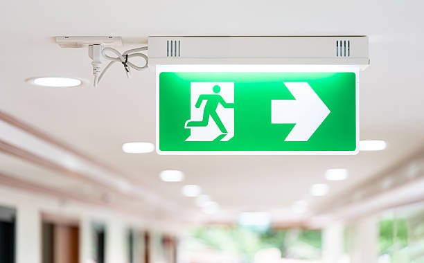 istock A Arrow light box sign of EMERGENCY FIRE EXIT is hung on the ceiling in hospital walkway, Idea for event fire or evacuation drills. 2252133312
