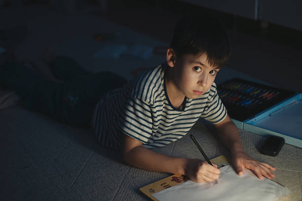 istock Child Studies Diligently, Young Boy Diligently Completes Assignments On Ground Beneath Cozy Lamp Light 2252133558