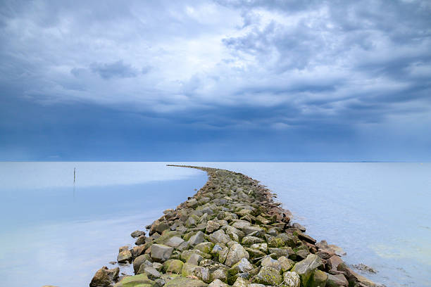 Storm clouds over a dam in the IJsselmeer during a springtime day along the IJsselmeer lakeshore.