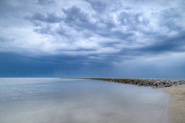 Storm clouds over a dam in the IJsselmeer during a springtime day along the IJsselmeer lakeshore.