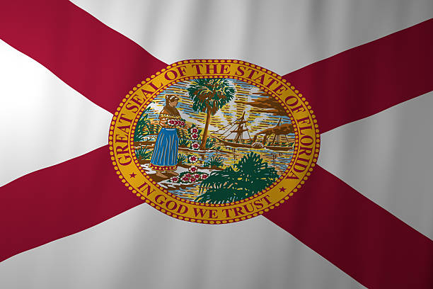 The official flag of Florida featuring a red saltire on a white background with the state seal at the center. The seal depicts a coastal scene symbolizing Florida’s history, natural beauty, and cultural heritage.