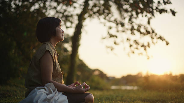 istock Mature woman meditating in nature. 2252140409