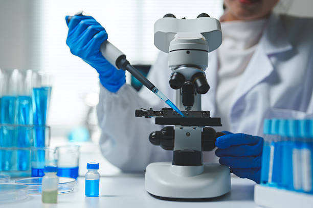 istock Close-up of a scientist's hands using a micropipette to place a sample on a microscope slide, surrounded by laboratory equipment and blue liquids, conducting research in a modern laboratory setting 2252144395