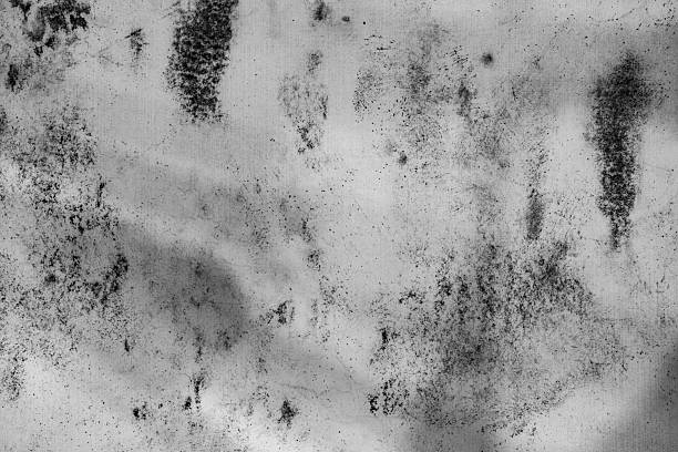 A weathered surface featuring irregular stains, smudges, and aged paint. Ideal for backgrounds, textures, and design concepts conveying age, decay, and mystery. Grunge Texture Design Element.