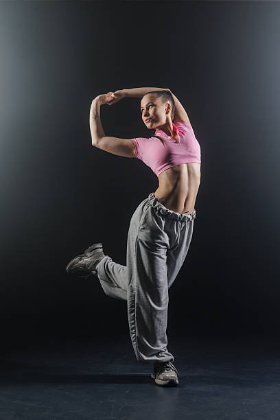 istock One leg balance jazz funk hip hop pose under studio spotlight on dark background 2252149702