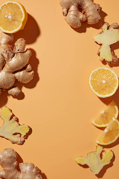 istock Flat lay with fresh yellow lemon slices and raw ginger roots on a orange background. Natural ingredients for detox juice, healthy drinks, blank space for design and add 2252150732