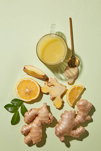 istock Top view composition with a cup, ginger roots, lemon slices, and apple slice on a soft green background. Ingredients of herbal tea, cold relief, and healthy drink preparation. 2252151297