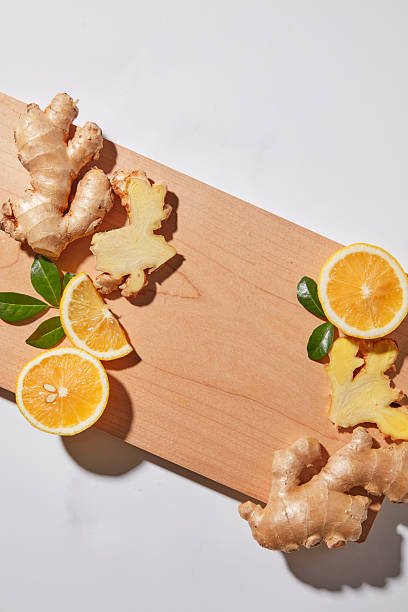 istock Flat lay with lemon slices and ginger arranged around a wooden board on white background. Ideal for recipe, detox drink, and clean lifestyle visuals. Empty space for design 2252151387