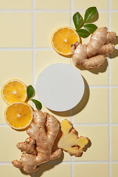 istock An empty round podium display with lemon and ginger on yellow tiles background. The clean space for product placement, design and branding 2252151407