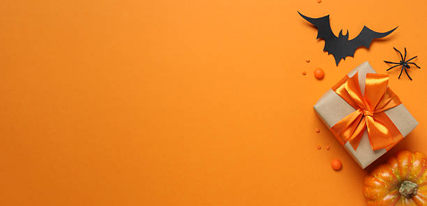 istock Various Halloween decorations including pumpkin, spider, bat, confetti and gift box on color background 2252152032