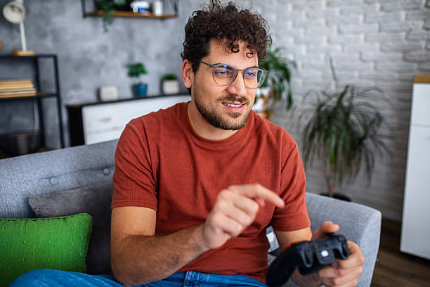 istock Man Playing Video Games with Game Controller at Home 2252152239