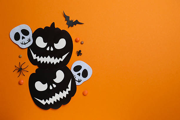 istock Halloween festive background design featuring black pumpkin, skulls, bats, spiders and confetti. Top view, space for text 2252157144