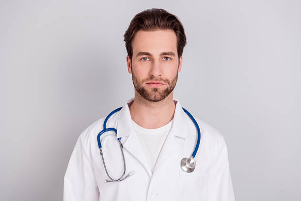 istock Photo of positive thoughtful young doc man dressed white coat smiling looking empty space isolated grey color background 2252161736