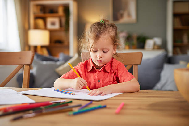 istock Young girl drawing on paper at home table 2252166180
