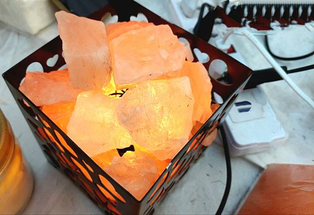 Large pieces of healthy orange and raw himalayan salt placed on a table, indoor. No people. Kitchen surrounding.