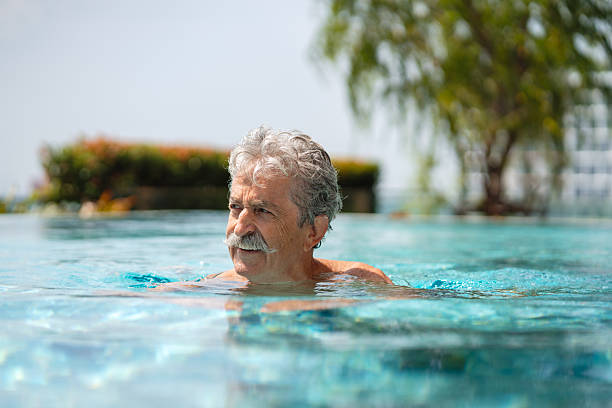 istock Senior man is swimming in a pool 2252169034