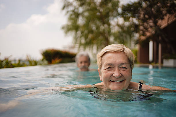 istock Senior couple swimming in infinity pool 2252169089