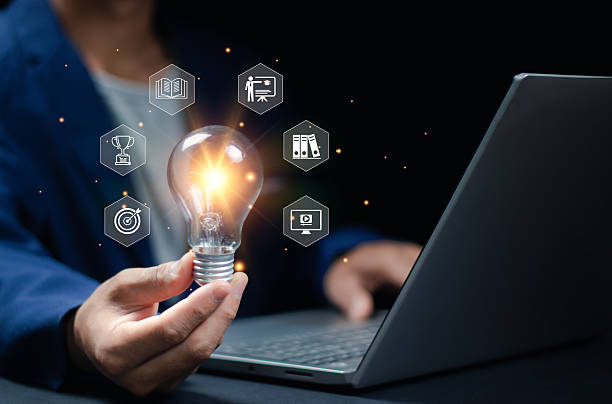 istock A businessman is holding a shining lightbulb that features learning icons for concepts in critical thinking, study skills, and problem-solving. 2252169366