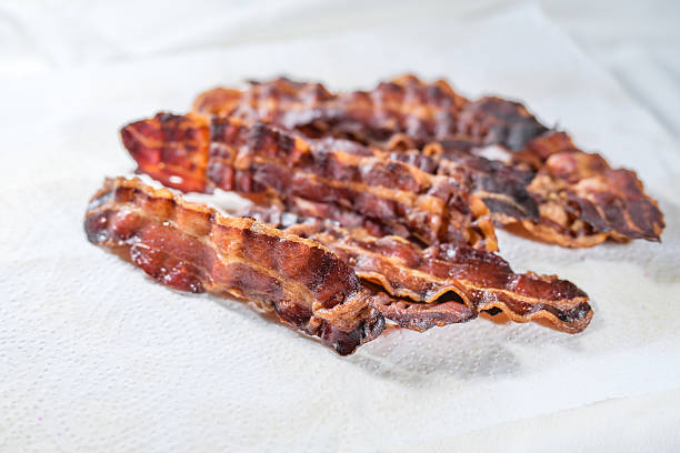 istock Crispy fried bacon strips from the oven draining on white kitchen paper, copy space, selected focus 2252169762