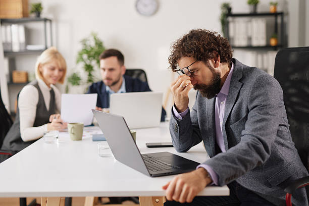 istock Employees face business problems and express tiredness in a modern office during working hours while collaborating on tasks 2252174562