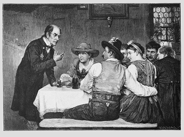 Men and women in traditional clothing are seated closely around a table while a man in a dark frock coat addresses them in a serious interior setting