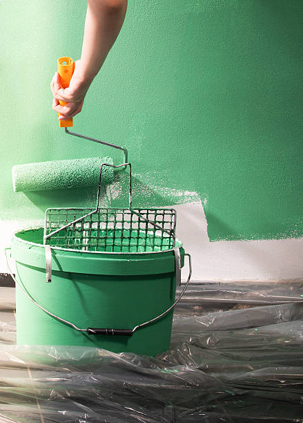 istock Young women painting a wall with paint roller 2252178818