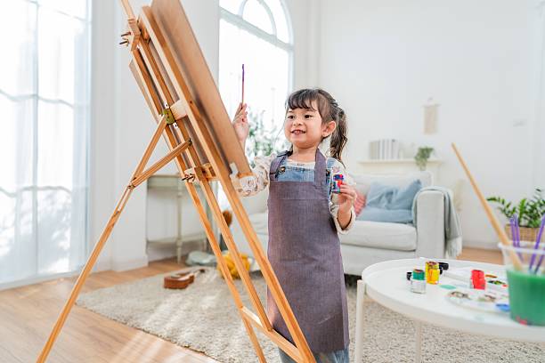 istock Young child paints on canvas in bright room with natural light during afternoon 2252179365