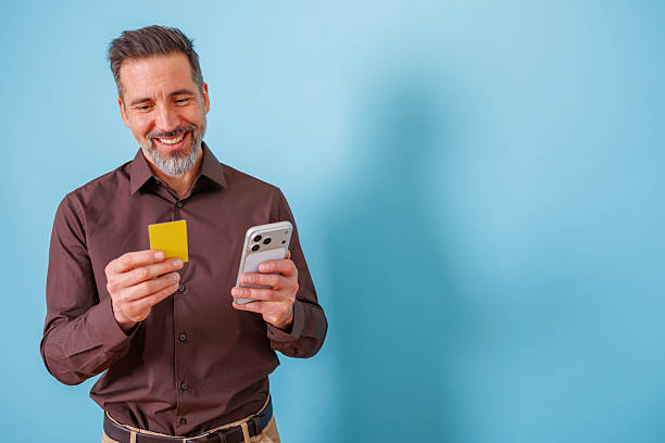 istock Man shopping online using smartphone and credit card, smiling for successful e-commerce payment 2252180634