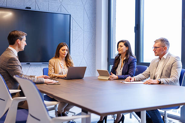 istock Four business people working together at a conference room table 2252181154