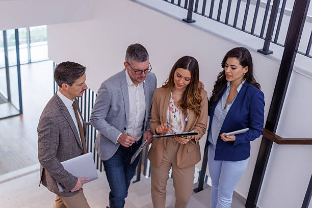istock Business people discussing document on office stairs 2252181184