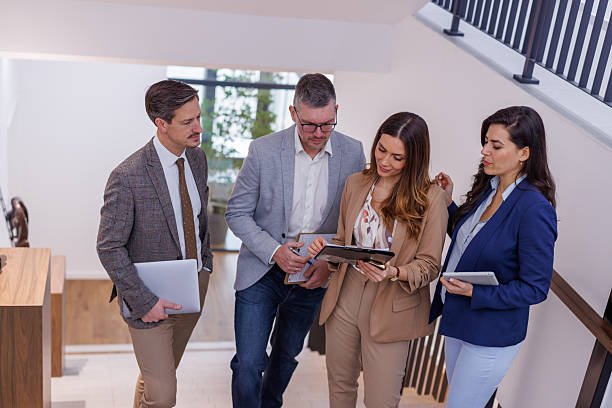 istock Business professionals discussing work walking down stairs 2252181251