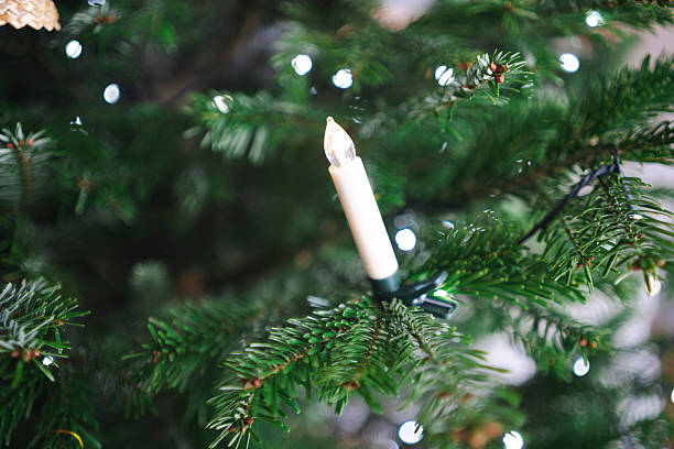 istock Lonely plastic Christmas candle hanging on tree with soft focus, minimal festive decoration detail 2252183947