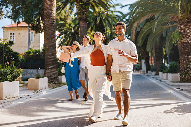 istock Joyful Diverse Couple Strolling on Scenic Palm Lined Avenue 2252184167