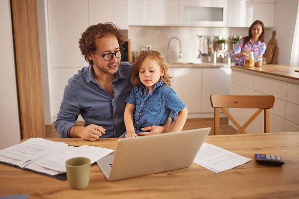 istock Father and child using laptop in home kitchen 2252184276