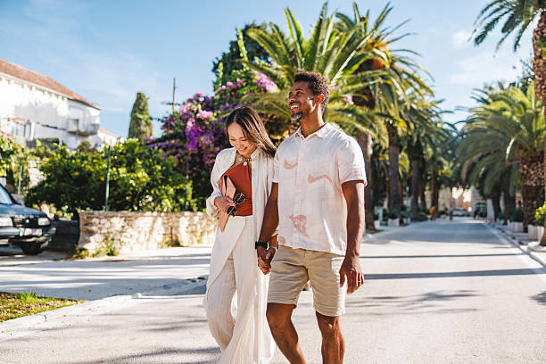 istock Joyful Pair Walking Hand in Hand on Bright Palm Avenue 2252184380