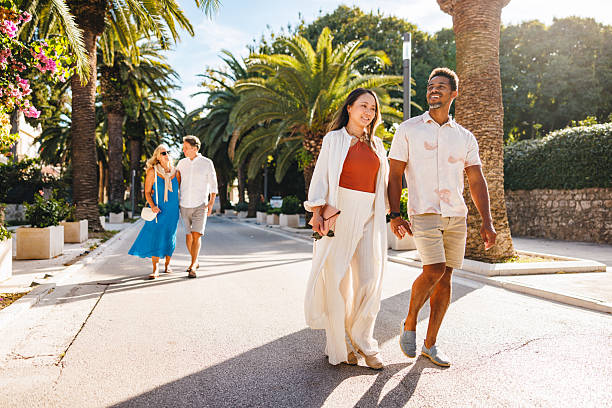 istock Delighted Couples Strolling on Palm Lined Dalmatian Street 2252184381