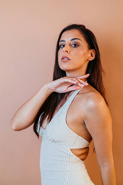istock Young Woman Posing Against A Brown Background In The Studio 2252184490