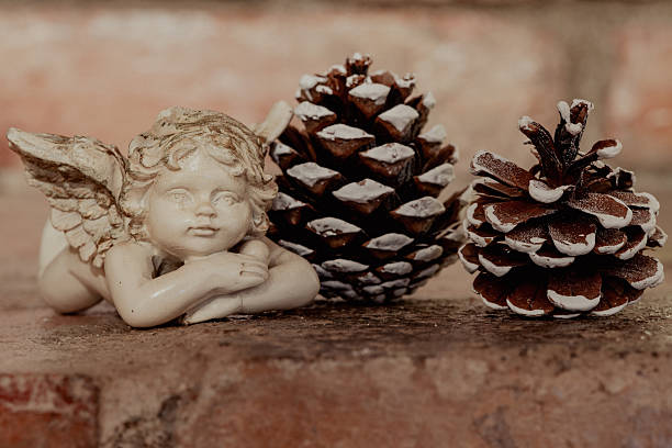 Angel Figurine with Frosted Pine Cones on Rustic Brick Surface