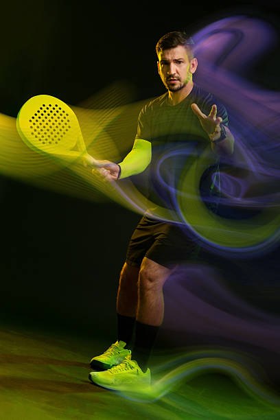 istock Man playing padel tennis with vibrant colors and dynamic movement in a dark setting 2252185743