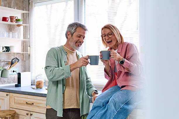 istock Mature couple laughing together drinking coffee in kitchen 2252188189
