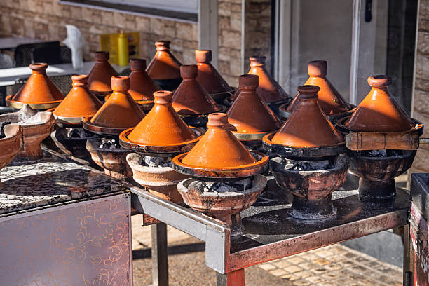 A collection of weathered terracotta oil lamps filled with charcoal remnants, arranged outdoors. The rustic, handmade bowls evoke traditional crafts and a warm, timeless atmosphere ideal for rustic or heritage settings.