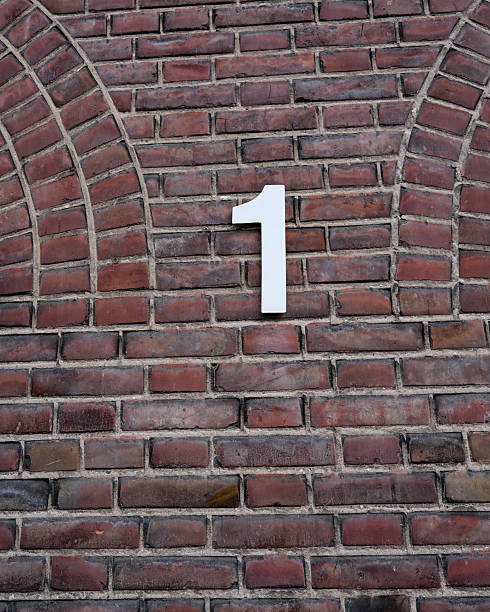 istock Distinctive white number one affixed on a red brick wall in a simple architectural setting during daytime 2252191795