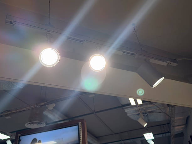 Three bright ceiling lights illuminate a stylish interior area filled with natural light