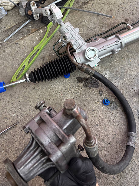 istock Mechanics work on a power steering system with tools and parts on a concrete surface 2252197209