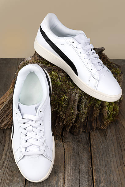 istock White sneakers on a moss-covered stump on a yellow background 2252206008